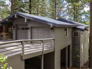 Discover this stunning mountain home featuring a modern metal roof and a spacious two-car garage, perfect for storing vehicles and outdoor gear.