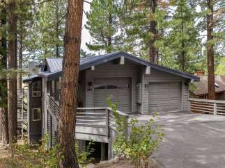 Nestled amidst tall pine trees, this modern home offers a serene mountain retreat.