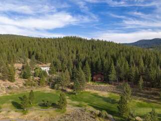 Nestled amidst a lush pine forest, this property offers a serene mountain retreat with a beautifully manicured golf course.
