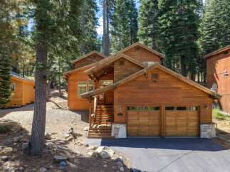 Nestled amidst towering pine trees, this charming wooden cabin offers a serene mountain retreat.