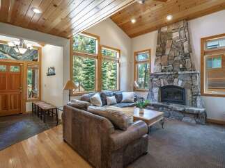 Experience rustic charm in this inviting living room, featuring a grand stone fireplace as the centerpiece.