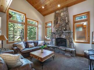 Experience rustic charm in this inviting living room, featuring a grand stone fireplace as the centerpiece.