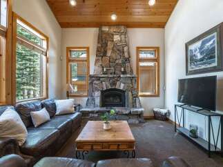 Experience rustic charm in this inviting living room, featuring a grand stone fireplace as the centerpiece.