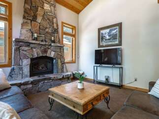 Cozy living room featuring a grand stone fireplace as the focal point, perfect for chilly evenings.