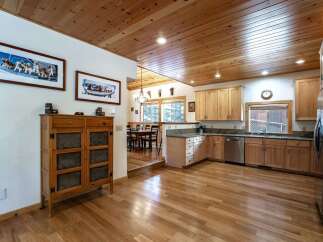 Experience rustic charm in this inviting kitchen and dining area, featuring warm wood ceilings and floors throughout.
