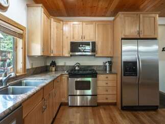 This spacious kitchen boasts beautiful light wood cabinetry and granite countertops, offering ample storage and workspace.