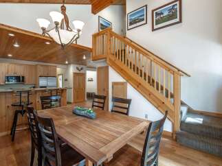 Experience rustic charm in this inviting dining area, featuring a warm wooden table and chairs perfect for family gatherings.