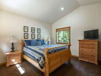 This charming bedroom features a cozy wooden sleigh bed adorned with blue and white striped bedding and plush pillows.