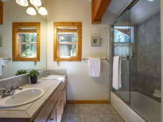 This charming bathroom features a dual vanity with ample counter space and two sinks, perfect for busy mornings.