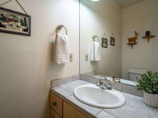 This charming bathroom features a spacious vanity with a tiled countertop and a white undermount sink, perfect for your morning routine.