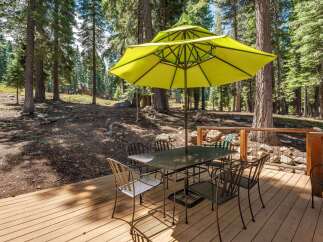 Enjoy outdoor dining surrounded by nature on this spacious wooden deck.