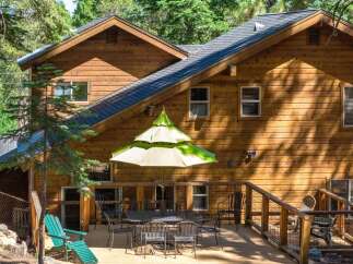 Enjoy outdoor living on this spacious wooden deck, perfect for entertaining or relaxing amidst the trees.