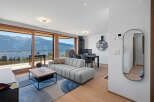 Experience breathtaking mountain views from this modern living space, featuring a plush sectional sofa and a stylish coffee table.