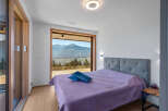 Experience breathtaking mountain views from this stunning bedroom, featuring a large sliding glass door that opens to a private balcony.