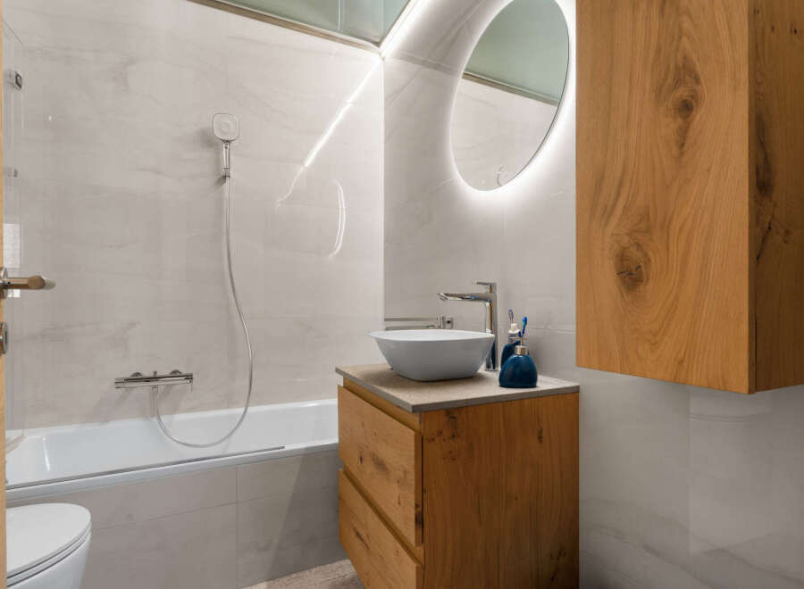 Experience modern luxury in this stunning bathroom, featuring a sleek bathtub and a stylish vanity with a vessel sink.