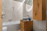 Experience modern luxury in this stunning bathroom, featuring a sleek bathtub and a stylish vanity with a vessel sink.