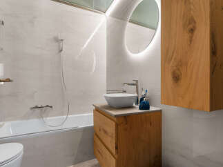 Experience modern luxury in this stunning bathroom, featuring a sleek bathtub and a stylish vanity with a vessel sink.
