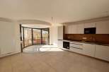 Discover modern living in this spacious apartment featuring a sleek, integrated kitchen with ample cabinet space and a built-in oven and microwave.
