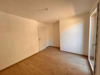 Experience modern living in this bright and airy room, featuring a pristine white door and a large glass door leading to an outdoor space.