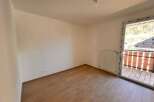 Experience modern living in this bright and airy room featuring a sleek white radiator and a sliding glass door that opens to a charming balcony.