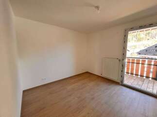 Experience modern living in this bright and airy room featuring a sleek white radiator and a sliding glass door that opens to a charming balcony.