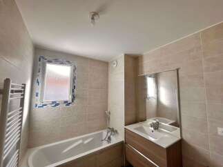 This modern bathroom features a spacious bathtub and a sleek vanity with a large mirror.