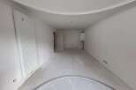 This unfinished room features a large vertical radiator on the left wall and a gas boiler mounted on the right wall.
