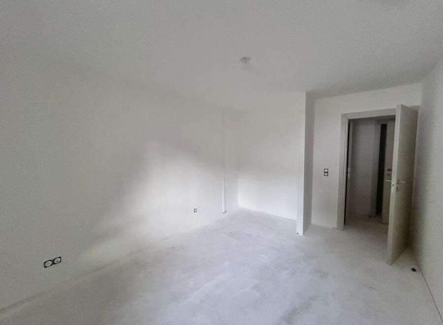 This unfurnished room offers a blank canvas for your design ideas, featuring freshly painted white walls and a smooth, light-colored floor.