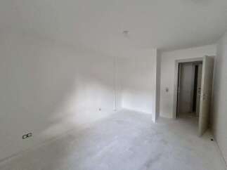This unfurnished room offers a blank canvas for your design ideas, featuring freshly painted white walls and a smooth, light-colored floor.