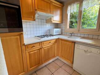 This charming kitchen features warm wooden cabinetry and a practical layout, perfect for everyday cooking.
