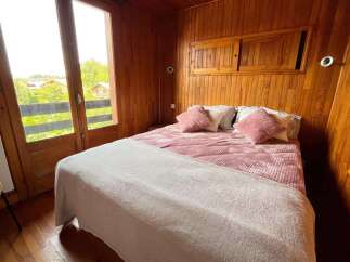 Experience cozy living in this charming bedroom featuring a comfortable bed adorned with plush pink pillows and a soft white throw.