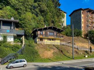 Charming wooden chalet nestled on a hillside, offering picturesque views and a serene mountain atmosphere.