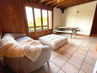 Experience cozy living in this charming room featuring a plush sofa draped with a chunky knit blanket, perfect for relaxing evenings.