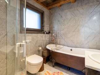 Experience rustic luxury in this stunning bathroom featuring a freestanding copper bathtub with ornate claw feet, perfect for a relaxing soak.