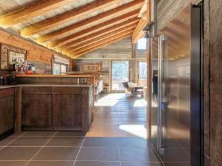 Experience rustic charm in this mountain chalet kitchen, featuring exposed wooden beams and a vaulted ceiling that creates an airy, spacious feel.