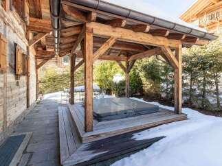 Experience ultimate relaxation in this charming alpine retreat, featuring a covered outdoor hot tub perfect for unwinding after a day on the slopes.