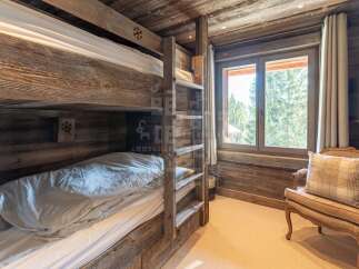 Experience rustic charm in this cozy cabin bedroom featuring a sturdy wooden bunk bed, perfect for families or guests.