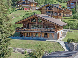 Experience luxury mountain living in this stunning chalet, featuring a spacious multi-level design with expansive windows offering breathtaking views.