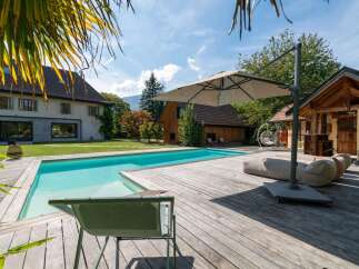 Experience luxury outdoor living with this stunning property featuring a crystal-clear swimming pool and expansive wooden deck.