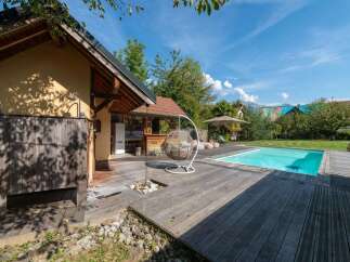 Experience outdoor living at its finest with this stunning property featuring a sparkling swimming pool and a spacious wooden deck, perfect for entertaining.