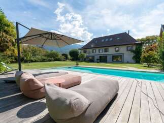 Experience luxurious outdoor living with this stunning property featuring a sparkling swimming pool and a spacious wooden deck.