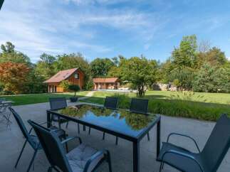 Enjoy outdoor living with this stunning patio featuring a modern glass-top dining table and comfortable chairs, perfect for al fresco meals.