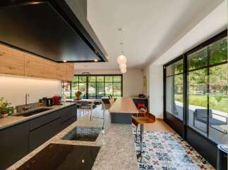 Experience modern living in this stunning kitchen featuring sleek dark cabinetry, a granite countertop, and a large island perfect for entertaining.