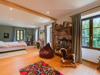 This charming bedroom features a cozy bed, a wooden bookshelf filled with books and decorative items, and a playful rocking horse.