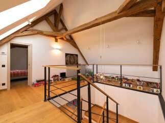 Discover this charming attic space featuring exposed wooden beams and a bright, airy atmosphere.