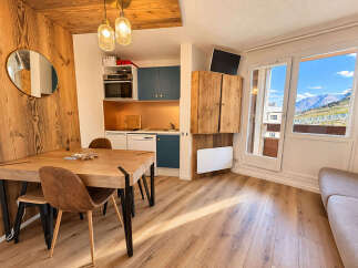 Experience cozy mountain living in this charming studio apartment, featuring a warm wood-paneled interior and a compact, functional kitchen.