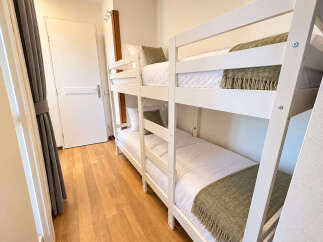 This charming room features a space-saving white bunk bed, perfect for families or guests.