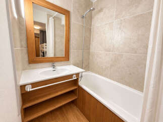 This modern bathroom features a spacious vanity with ample storage and a large mirror, perfect for your morning routine.