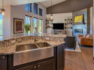 Experience luxury living in this stunning open-concept home, featuring a gourmet kitchen with a granite island and a farmhouse sink.