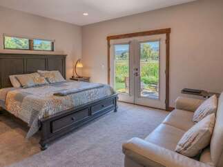 Experience comfort and tranquility in this inviting bedroom, featuring a plush king-sized bed adorned with a stylish quilt and decorative pillows.